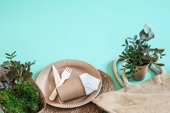 Servilleta de papel junto a vajilla ecológica